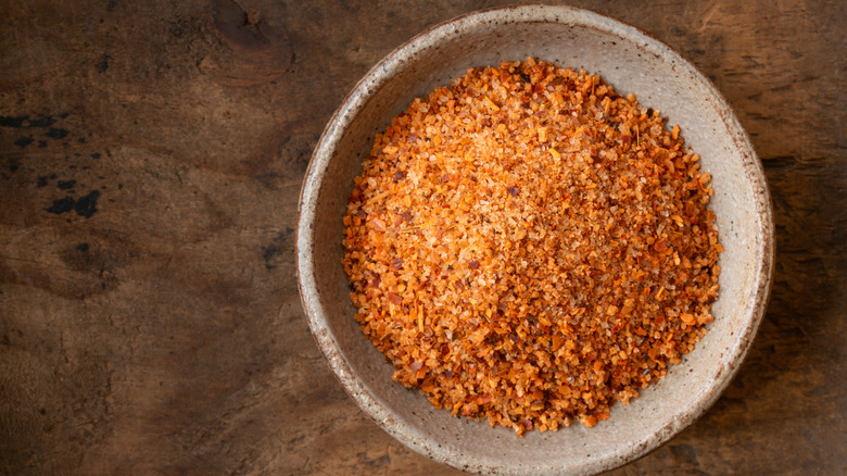 Takin seasoning in white bowl on brown table