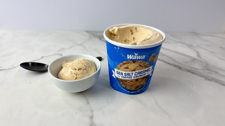 Wawa sea salt caramel toffee crunch ice cream carton and scoop in a bowl with a spoon