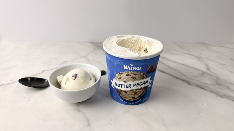 Wawa butter pecan ice cream carton and scoop in a bowl with a spoon