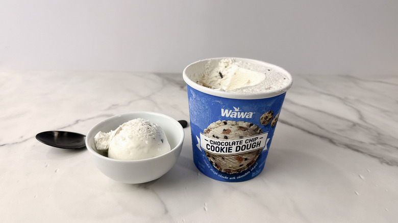 Wawa chocolate chip cookie dough ice cream carton and scoop in a bowl with a spoon