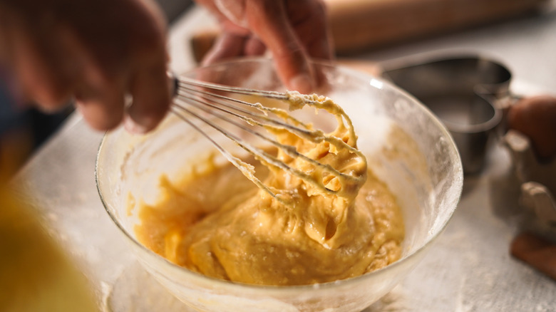 hands whisking batter in bowl