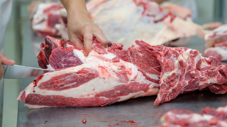 butcher cutting meat off a bone