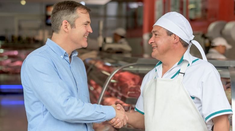 man shaking hands with butcher