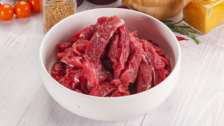 bowl of raw meat cut in strips