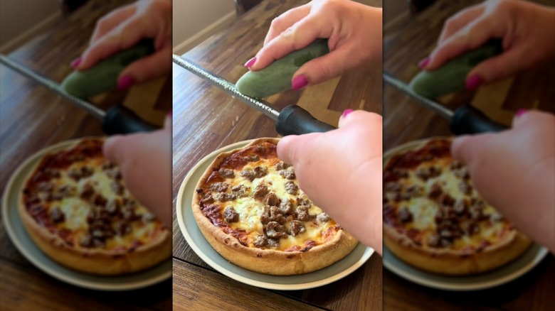 Person using a microplane to grate a frozen jalapeño pepper over pizza