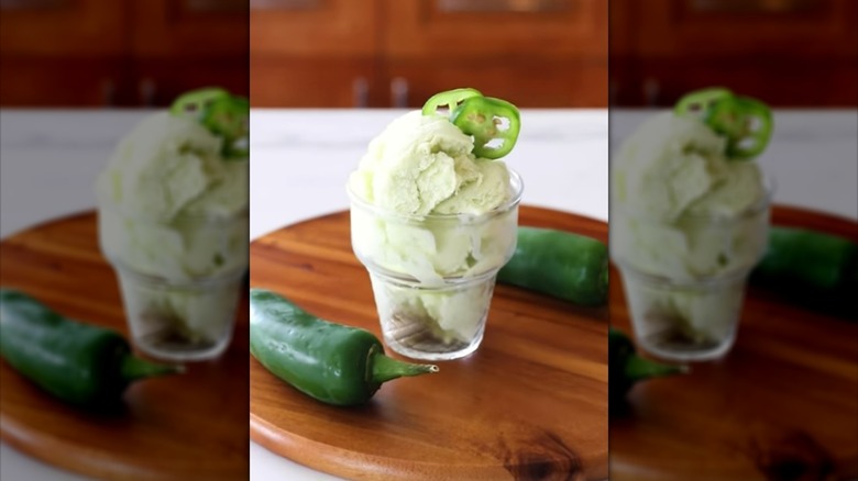 Scoops of jalapeño ice cream in a dessert glass, garnished with fresh jalapeño slices