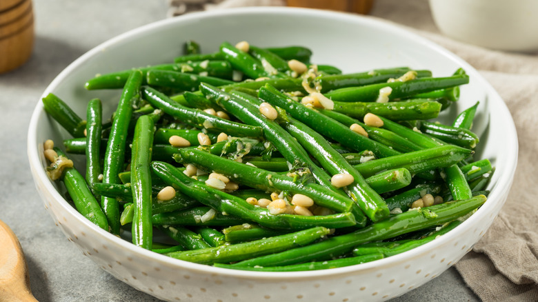 Bowl of sauteed green beans with pine nuts