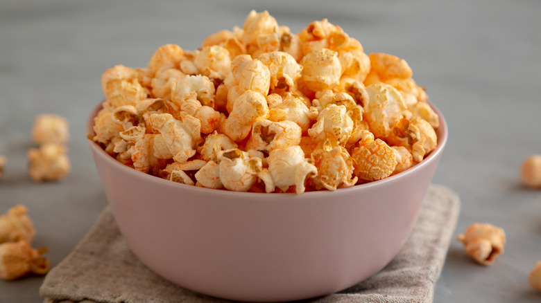 Bowl of cheesy popcorn on a kitchen towel