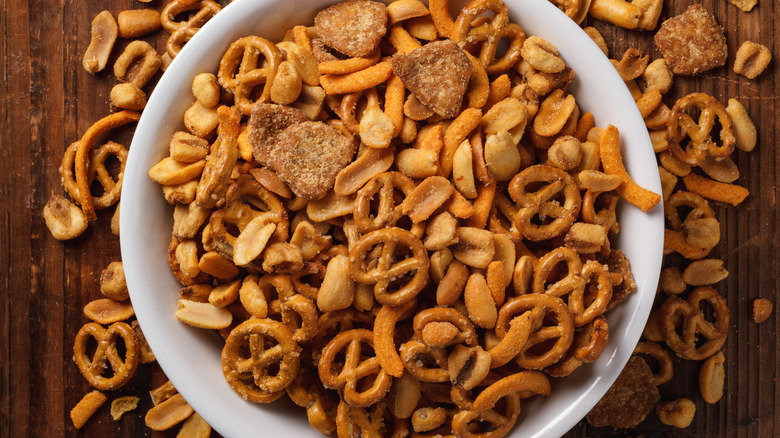 Bowl of savory snack mix on a wooden tabletop