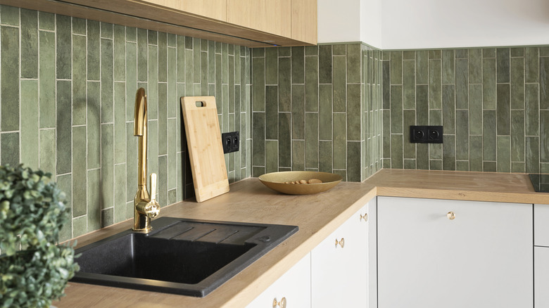 Minimalist kitchen with band of green tiles