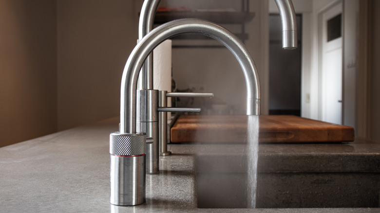 stainless steel faucet with water pouring out