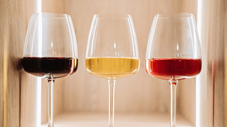 red, white, and rose wine in three glasses