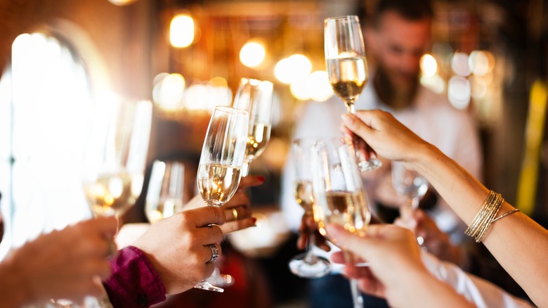 people clinking champagne glasses