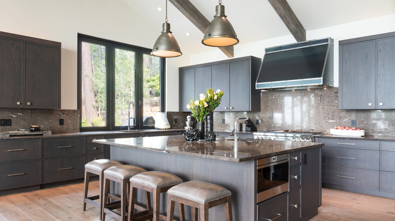 Kitchen interior with white walls, gray cabinets and steel appliances