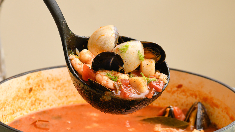 Italian fish and tomato stew in ladle