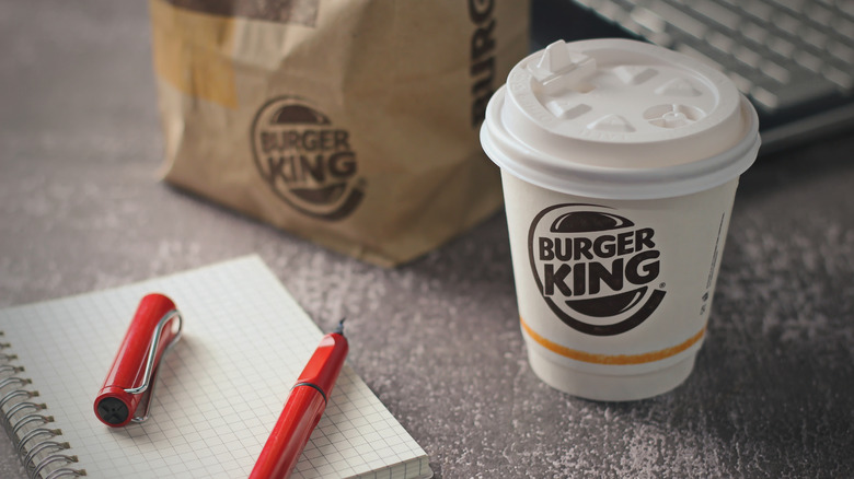 burger king coffee cup with food bag and pen and paper