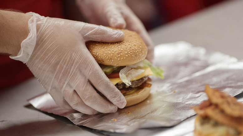 Five Guys employee preparing to wrap burger in foil