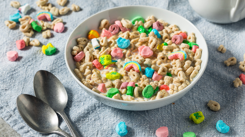 bowl of Lucky Charms in milk on cloth with spoons