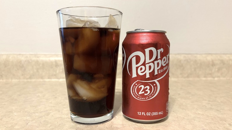 Dr Pepper in can and glass on neutral background.