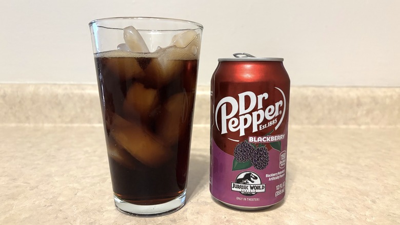 Dr Pepper Blackberry in can and glass on neutral background.