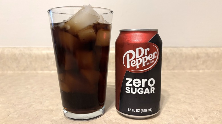 Dr Pepper Zero in can and glass on neutral background.