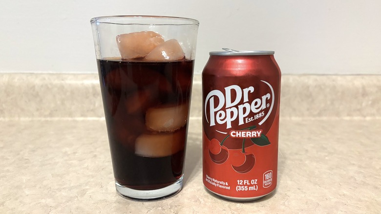 Dr Pepper Cherry in can and glass on neutral background.