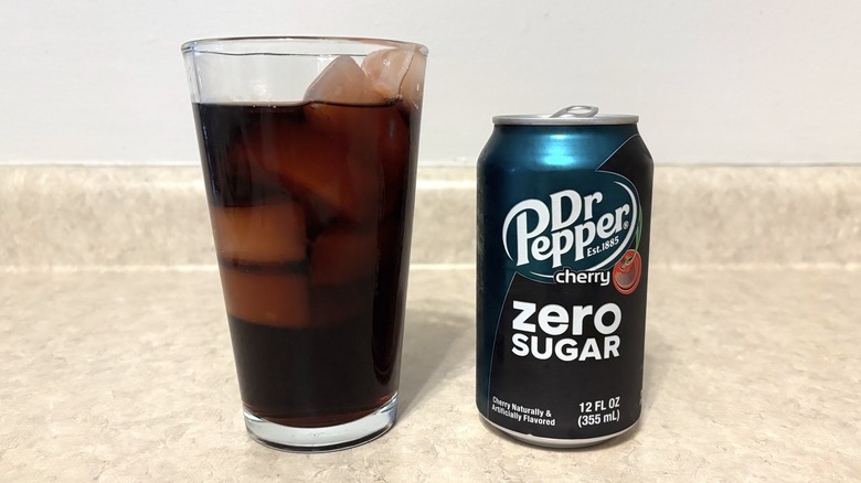 Dr Pepper Cherry Zero in can and glass on neutral background.