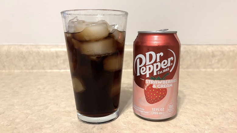 Dr Pepper Strawberries & Cream in can and glass on neutral background.