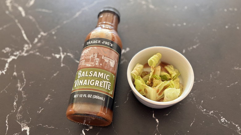Trader Joe's balsamic vinaigrette dressing bottle next to small bowl of salad