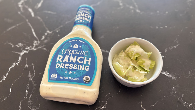 Trader Joe's organic ranch dressing bottle next to small bowl of salad