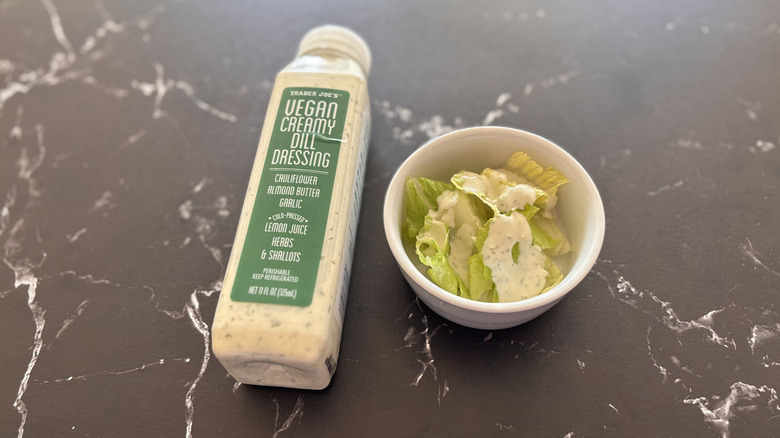 Trader Joe's vegan creamy dill dressing bottle next to small bowl of salad