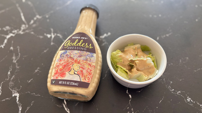 Trader Joe's goddess dressing bottle next to small bowl of salad