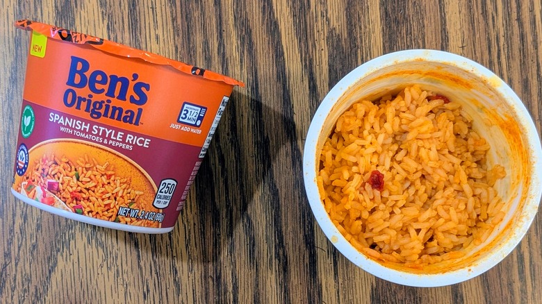 A top view of orange rice in a plastic cup next to a sealed cup of Ben's Original Spanish rice