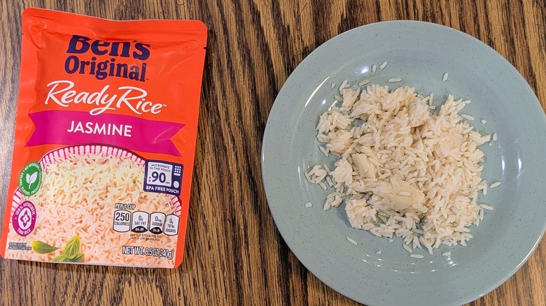 White rice on a light blue plate next to an orange pouch of Ben's Original jasmine rice