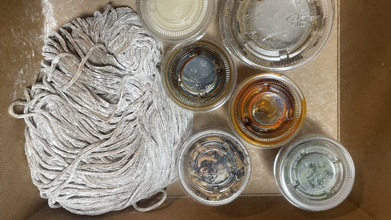 Overhead shot of a ball of noodles and several pots.