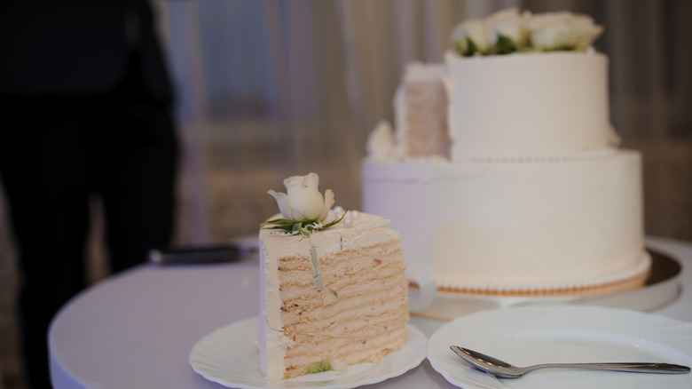 slice of wedding cake next to full cake