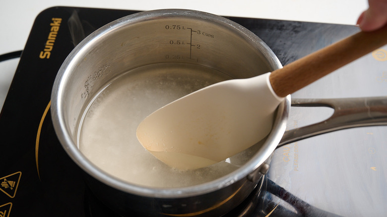 stirring sugar into simmering water