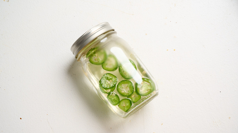 jalapeno slices steeping in a jar of simple syrup