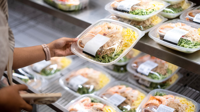 person picking up prepared meal from grocery store