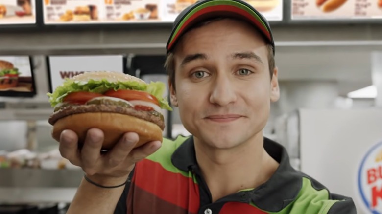 Employee holding a Whopper still from BK's Google Home hack commercial