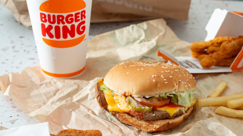 Burger King's Whopper on paper with chicken strips, fries, and drink