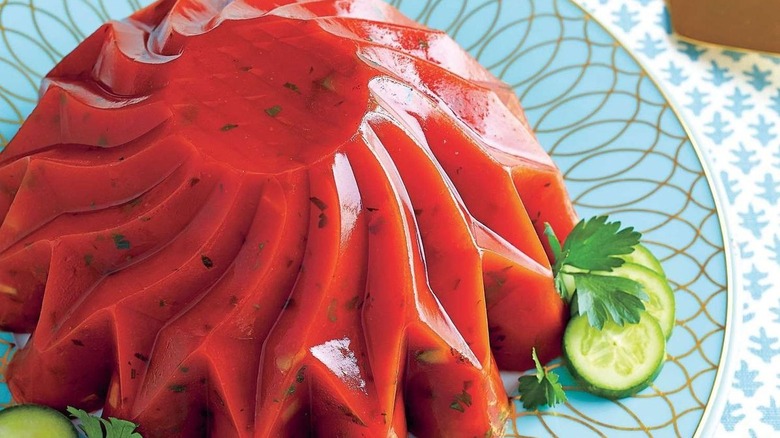 a plate with tomato aspic and a green garnish