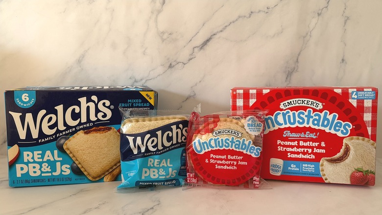 Welch's and Uncrustables sandwich boxes side by side with packaged individual sandwiches in front
