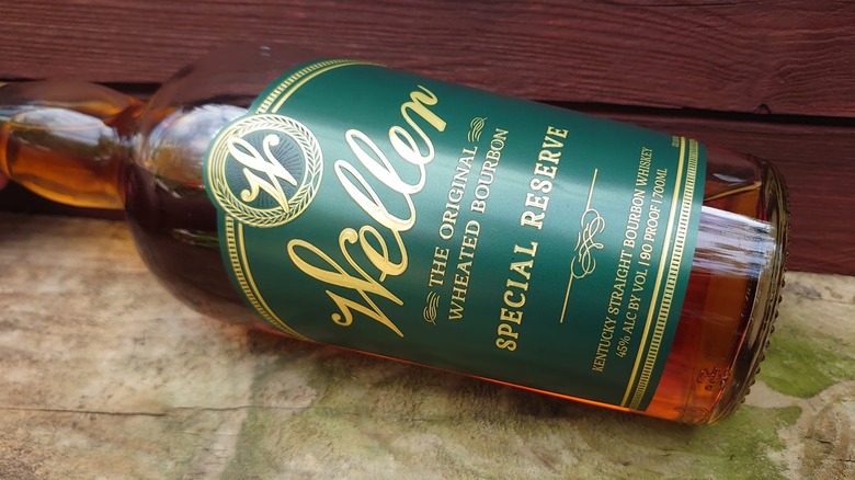 A bottle of Weller Special Reserve laid on its side with a wooden background