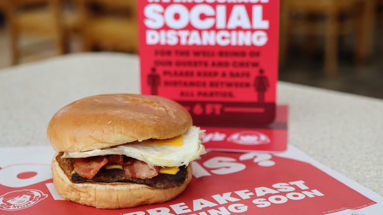 Wendy's Baconator with social distancing sign in the background