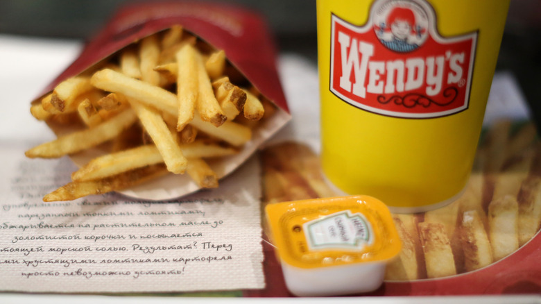 Close-up of Wendy's logo on yellow cup and fries