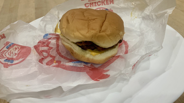 Bacon Double Stack burger on top of paper wrapper on white plate