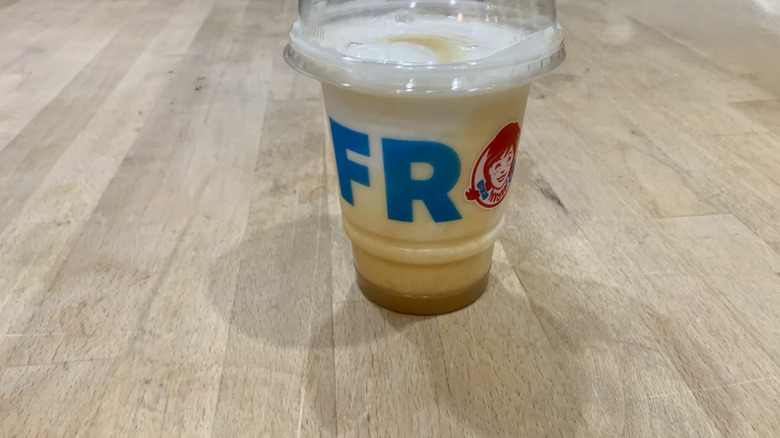 Caramel Vanilla Swirly Frosty in clear plastic up on wood background