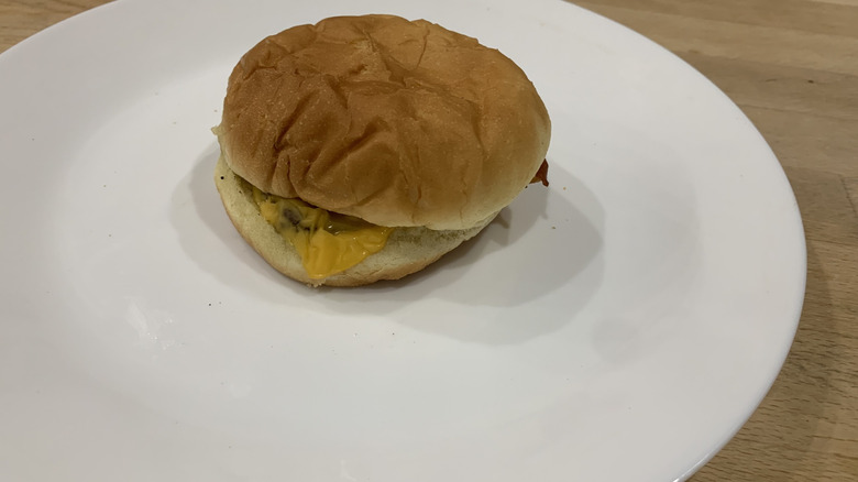 Jr. Bacon Cheeseburger on top of white plate on wood background