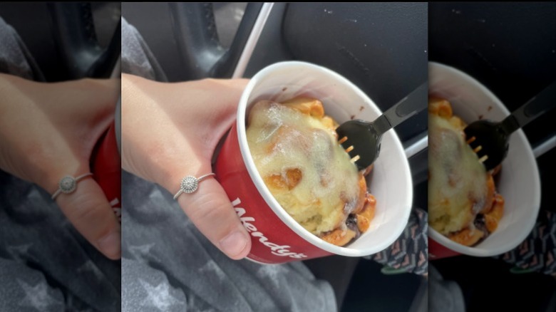 Woman digging fork into Wendy's Cinnabon